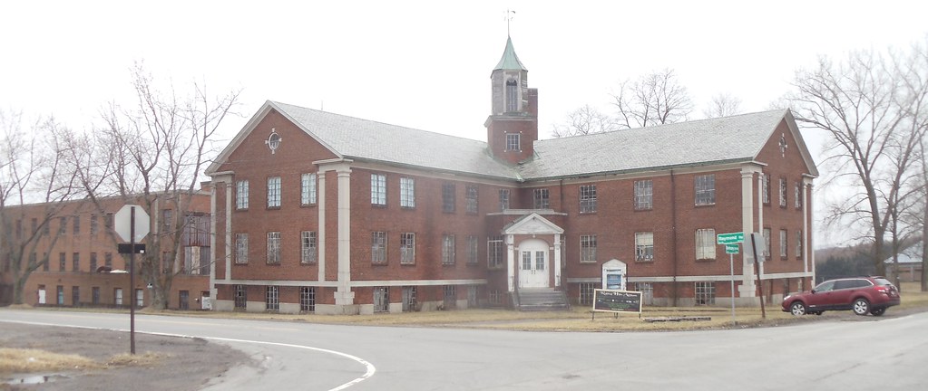 Photo shows the facade and front entrance of the rolling hills asylum against a cloudy sky