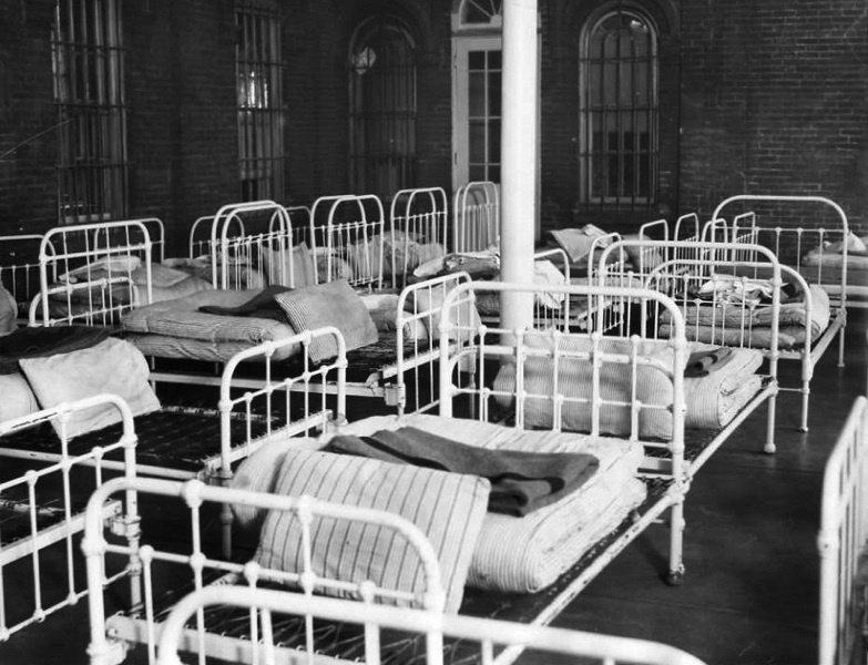 photo shows rows of hospital beds in black and white. 