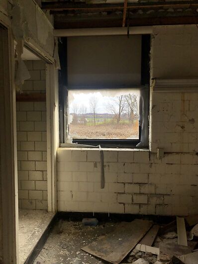 photo shows the trees outside through a broken window in one of the hospital rooms.