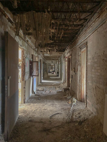 off white brick walls and hallways of Molly Stark Sanatorium falling into ruin