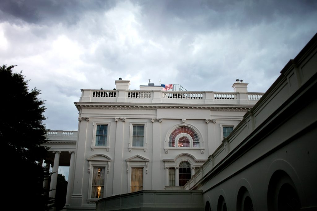 photo shows the facade of the executive residence at the white house against a cloudy sky