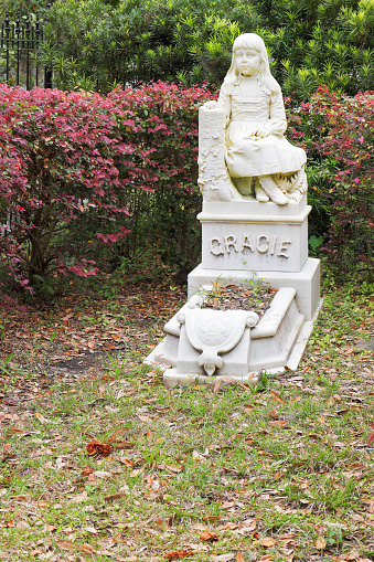 Photo shows the statue of gracie. it's a white granite type stone, showing her sitting with her legs crossed.
