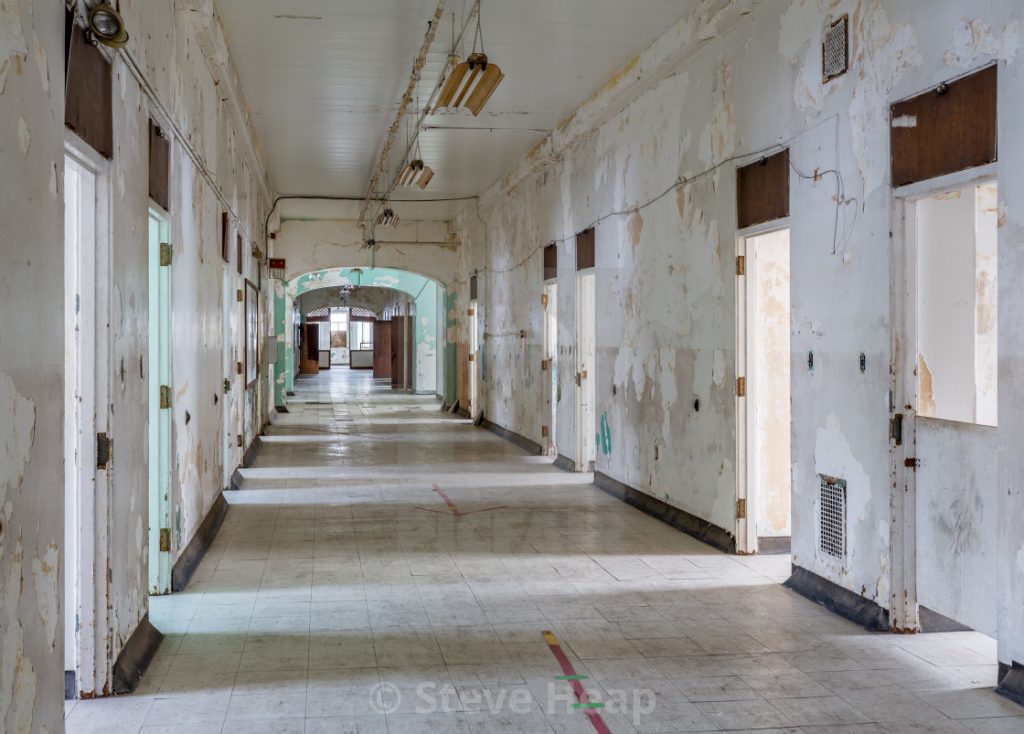 Photo shows a long hallway with peeling paint