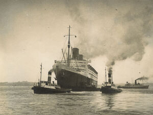 photo shows the rms queen mary sitting in the water, the photo looks like its from 1930
