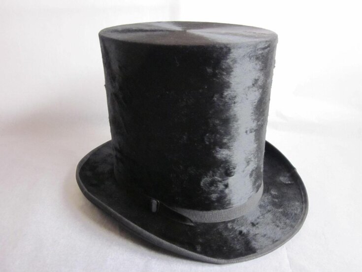 photo shows a black top hat against a white background