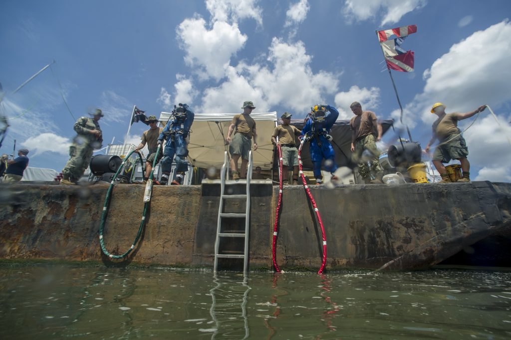 Members of Task Element CSS Georgia, assigned to Mobile Diving and Salvage Unit 2 (MDSU/2), stand at the waters edge in preparation for salvage operations in the Savannah River. Navy divers assigned to MDSU/2 and explosive ordnance disposal technicians assigned to Mobile Unit 6 are working in conjunction with archaeologists, conservationists, Naval History and Heritage Command and the U.S. Army Corps of Engineers in a project directed by Naval Sea Systems Command Supervisor of Salvage and Diving to salvage and preserve CSS Georgia. (U.S. Navy photo by Mass Communication Specialist 1st Class Blake Midnight/Released)