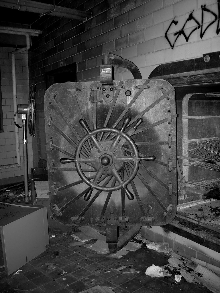 photo shows an autoclave with graffiti and decay surrounding it 