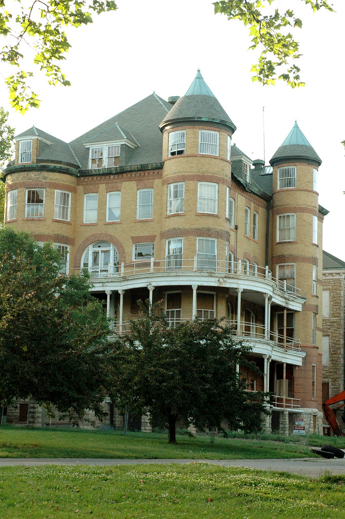 photo shows the facade of the topeka state hospital, its got 5 stories and a basement, the turrets are out in the front and there are two wrap around porch balconies 