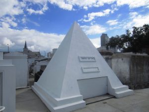 A large pyramid shaped tomb with a small entrance in front for caskets