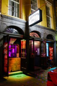 New Orleans Jazz club at night with black, green, yellow, purple and orange lighting. 