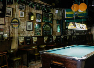 Bar interior with photos on the wall and a pool table
