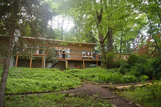 Jeffrey Dahmer house surrounded by lush trees and ground covering