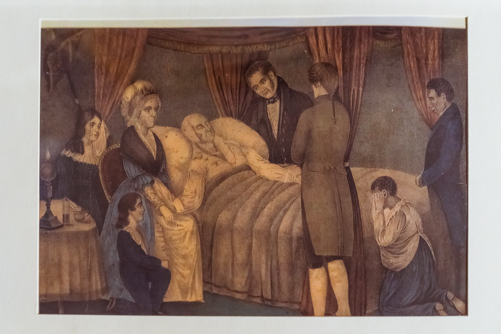 A drawing of George Washington laying on his deathbed surrounded by his family and supporters