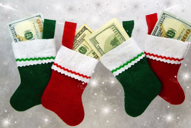 Four red and green christmas filled stockings with $100 dollar bills