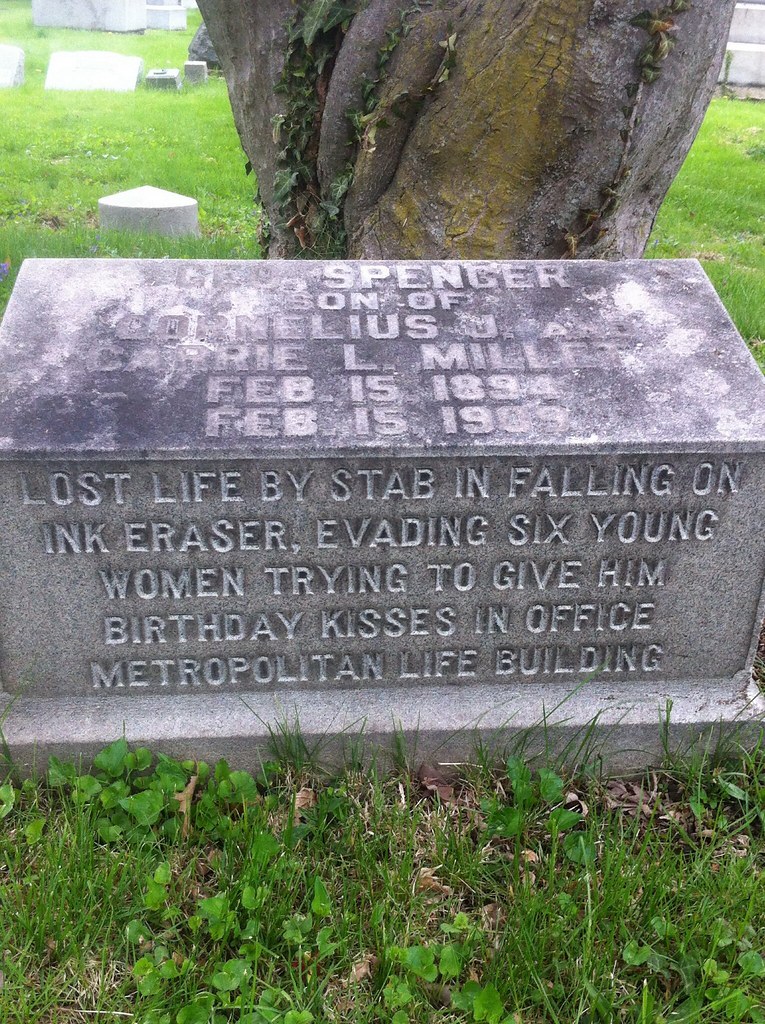 A tombstone that reads" Lost life by stab in falling on ink eraser, evading six women trying to give him birthday kisses in office metropolitan life building