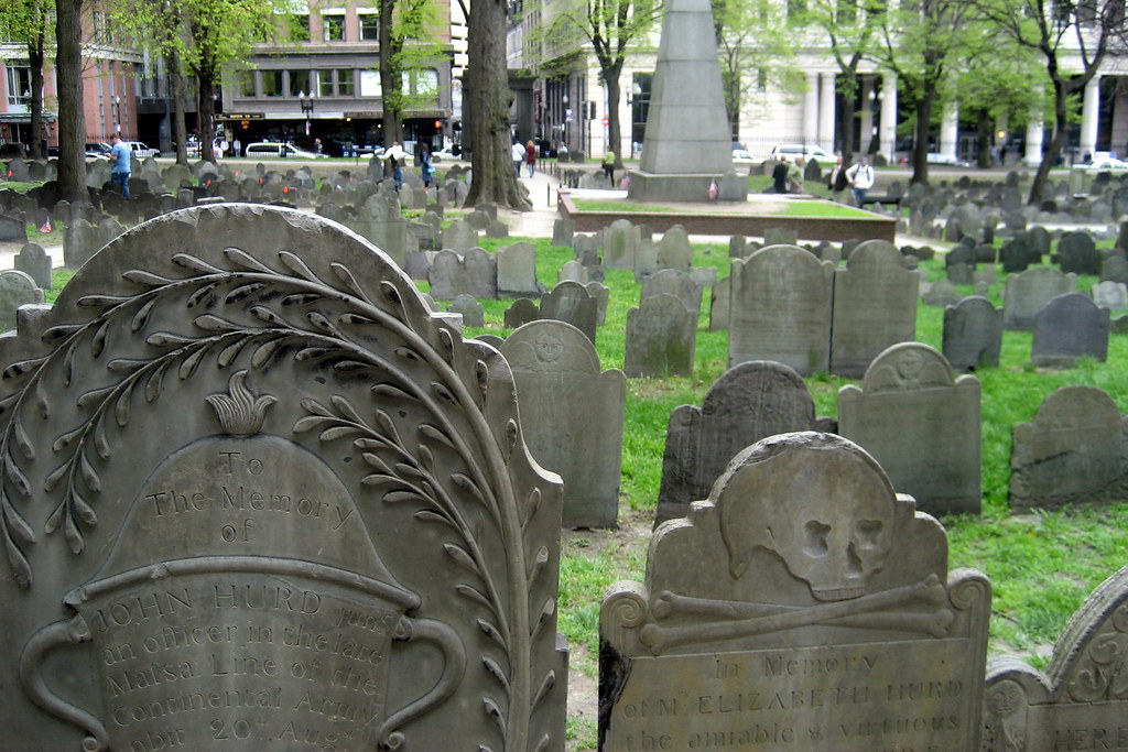 A large line of tombstones among green grass