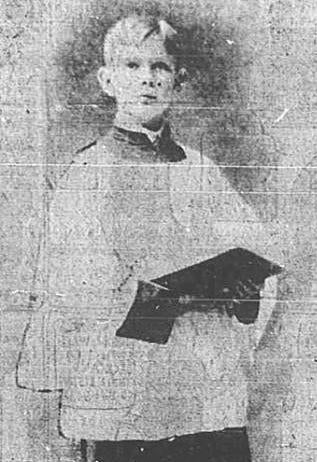A black and white photo of a blonde haired boy. Dressed what appears to be church robes holding what is most likely a bible.