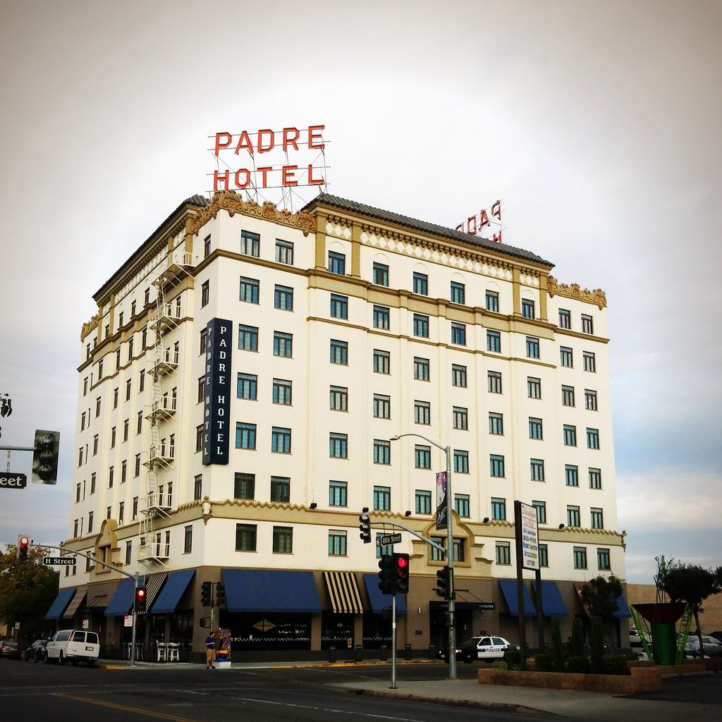 A large white hotel that says Padre Hotel in red neon letters above it