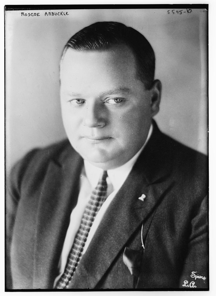 A black and white photo of a large man in a suit