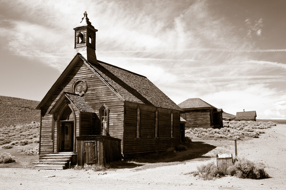 A large wooden church in an empty desert. 